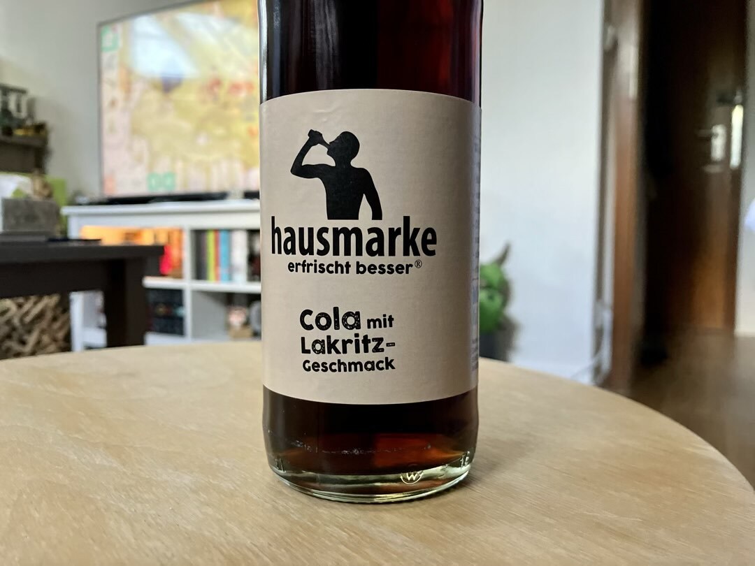 Eine Flasche Cola mit Lakritzgeschmack auf einem Tischchen.