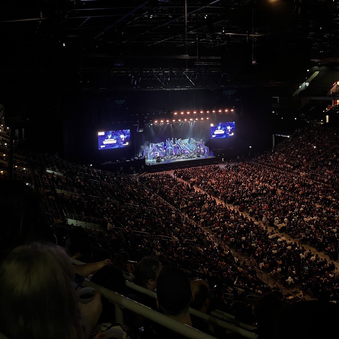 Die volle Uber Arena in Berlin. Auf der Bühne ist ein Spieltisch im Fantasy Setting aufgebaut.