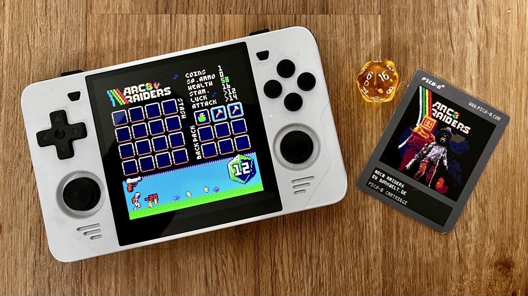 RGB30 mit unserem Spiel ARC8 Raiders, einem D20 und dem ausgedruckten PICO-8 Cartridge.