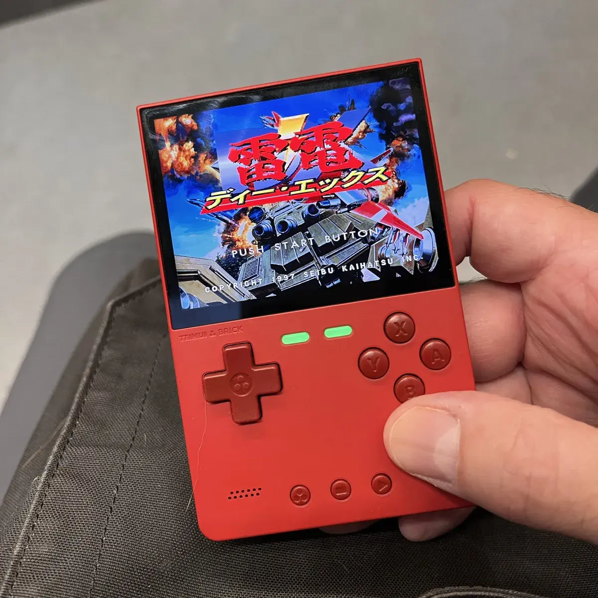 Ein TrimUI Brick Handheld, auf dem Raiden DX läuft.