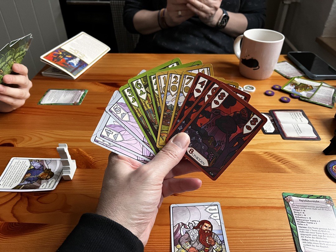 Spieltisch mit dem Herr der Ringe Stichspiel. Meine Hand ist noch voller Karten und ich spiele Gimli.
